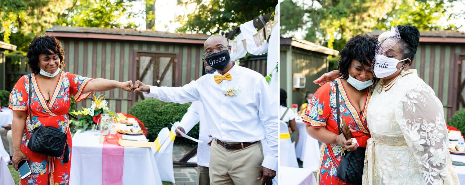 A groom in a mask fist-bumps one of his wedding guests, and his bride hugs the same guest while wearing her mask during their COVID-19 wedding