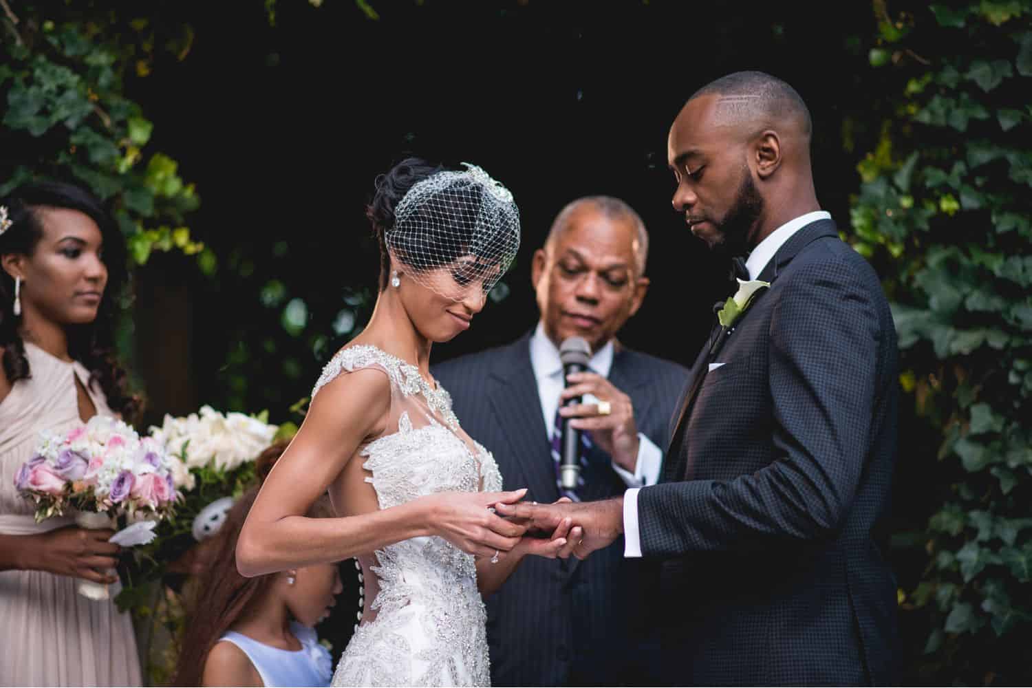 A bride putting a wedding ring on groom's finger