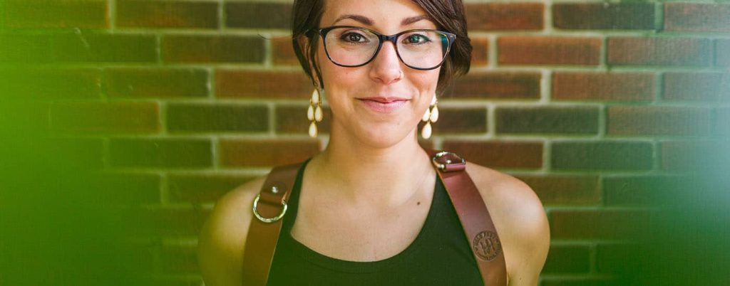 Photographer Mallory Regan smiling and wearing a HoldFast harness