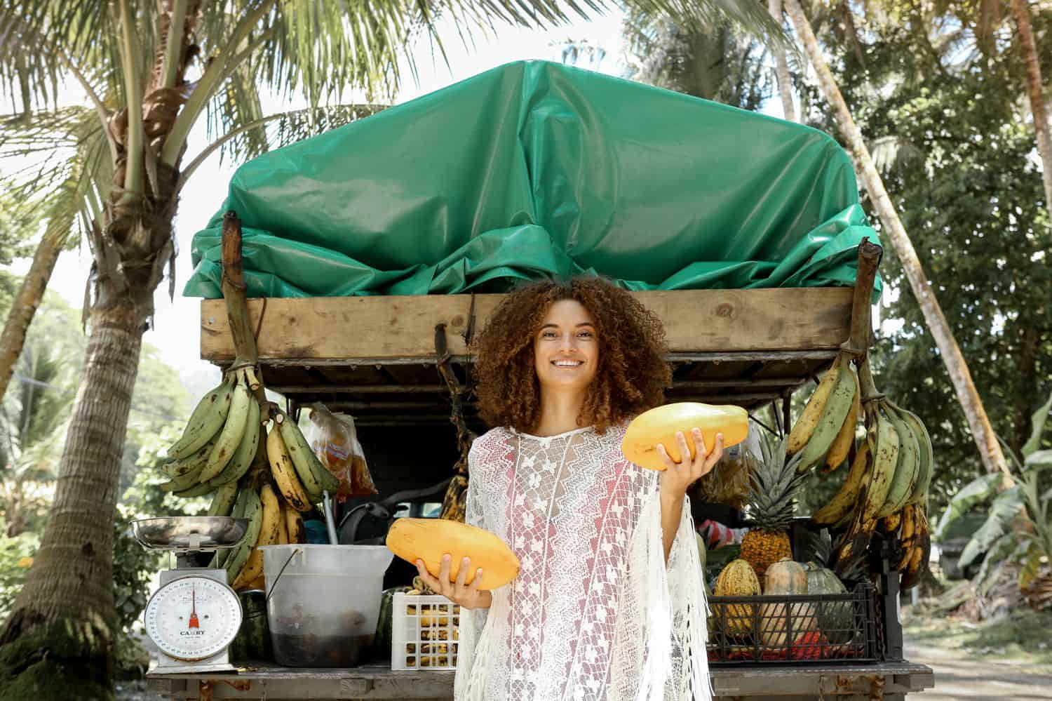 A woman posing in front of a fruit stand
