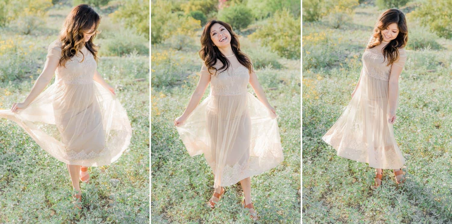 A pregnant mother twirls in a field in a pale pink dress