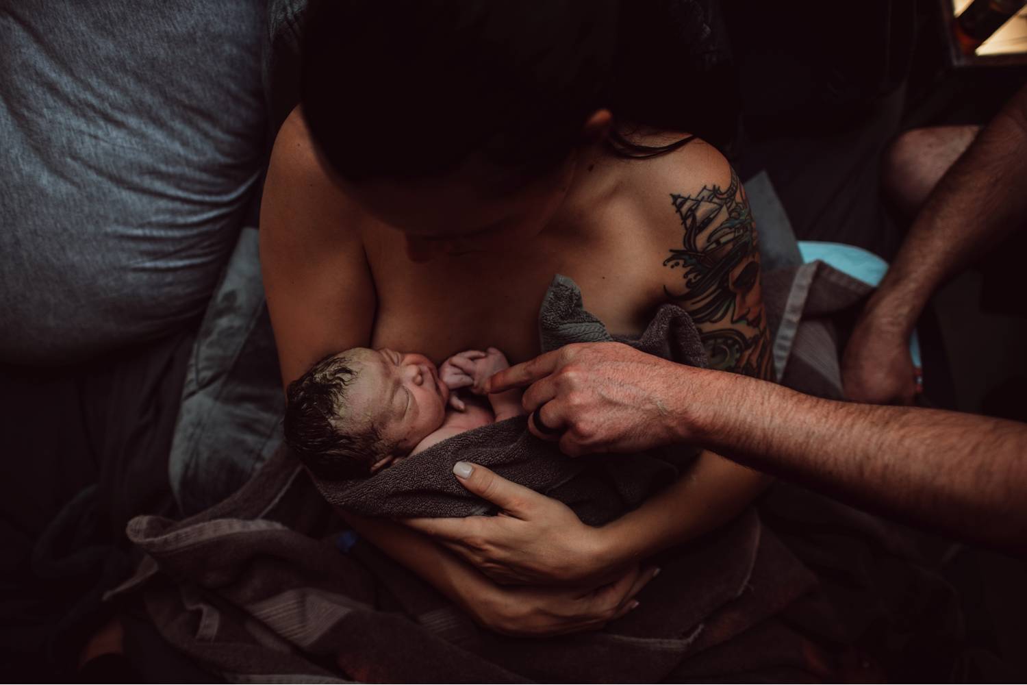 New parents cradle their infant moments after delivering the baby in a home birth