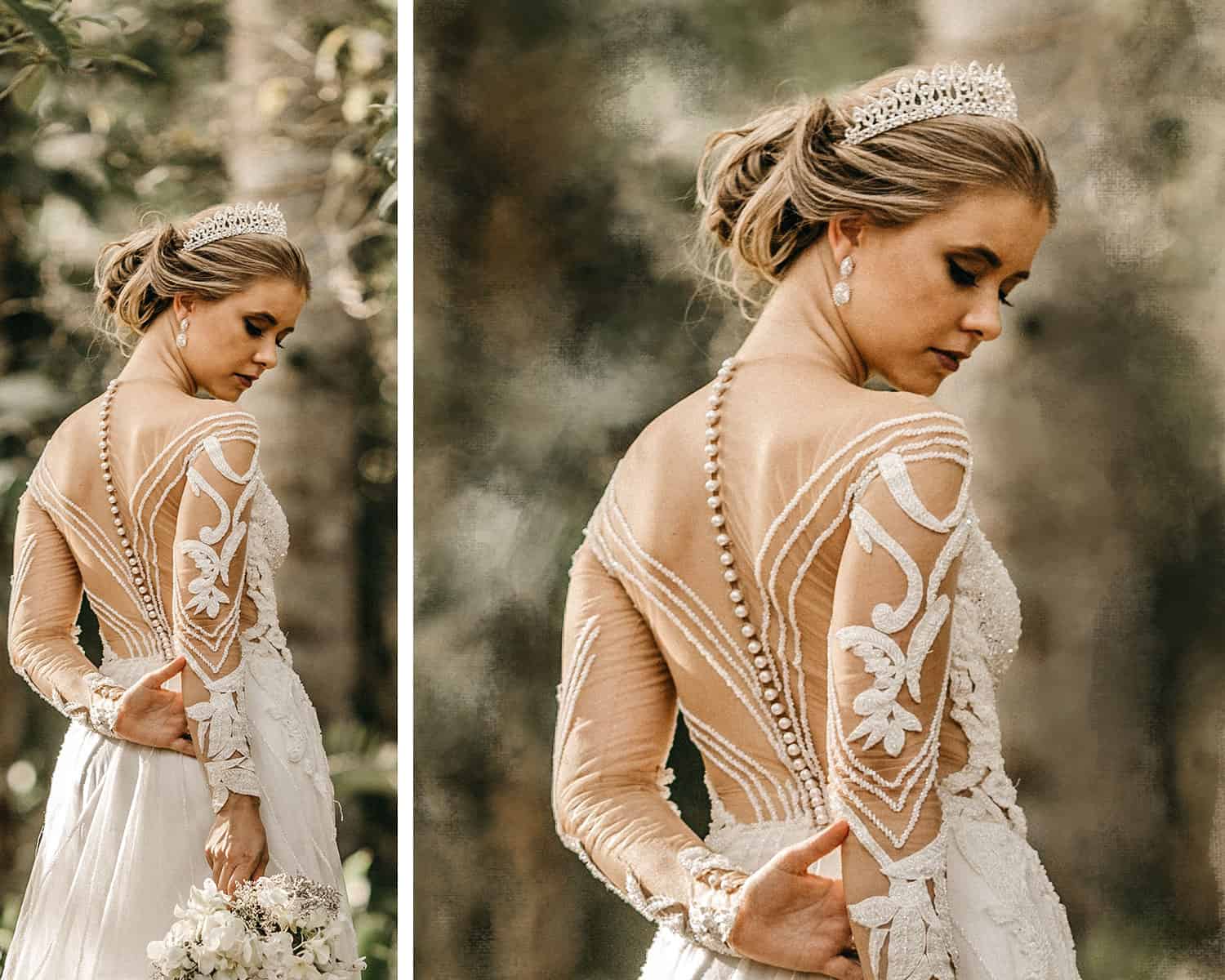 A blonde haired bride stands in a forest. Her back is partially to the camera, and a row of pearl buttons trails down her spine. She wears a tiara and gazes down at the ground. Her hands are clasped behind her.