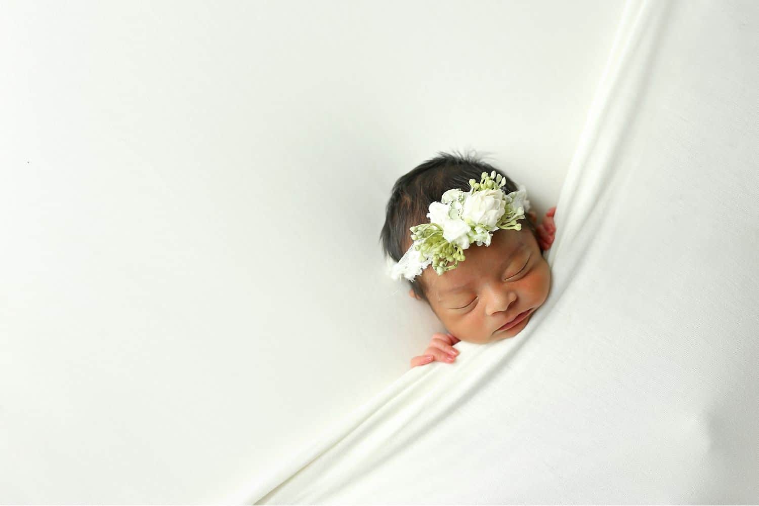 How To Attract New Clients In 3 Bold Business Moves: Baby tucked into blanket by Cassie Clayshulte