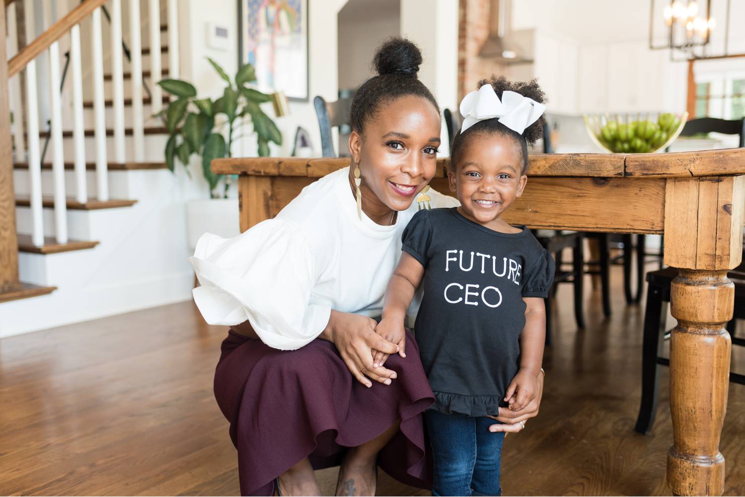 By Mandy Liz: A CEO poses in her dining room with her young daughter whose shirt reads "Future CEO." Great client feedback begins with confident leaders!