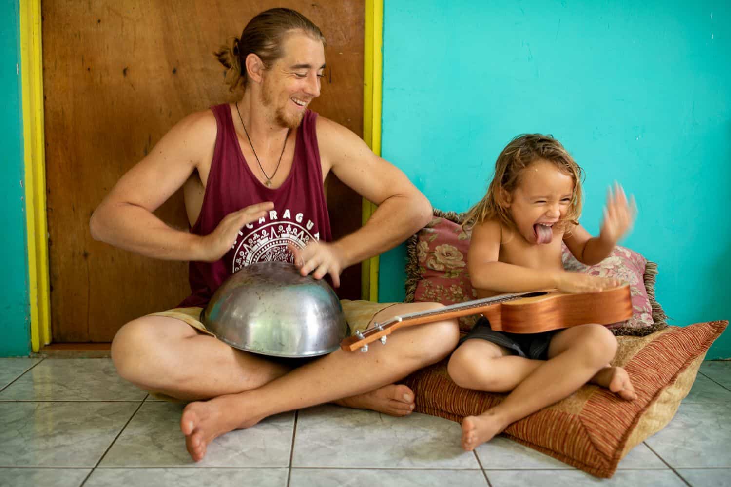 Dad and son making music on the kitchen floor.