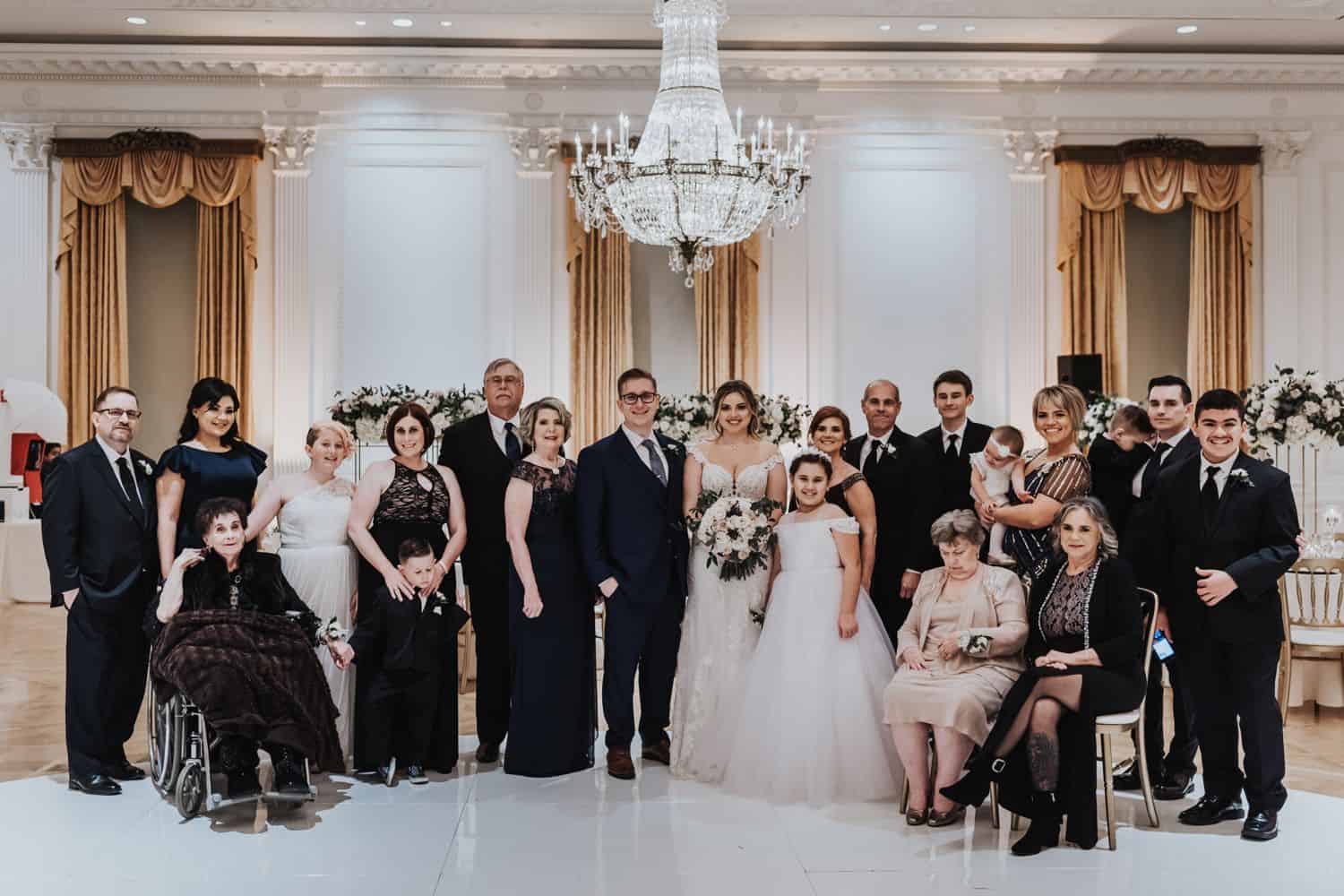 Large family grouping photographed at wedding with grandmother in wheelchair