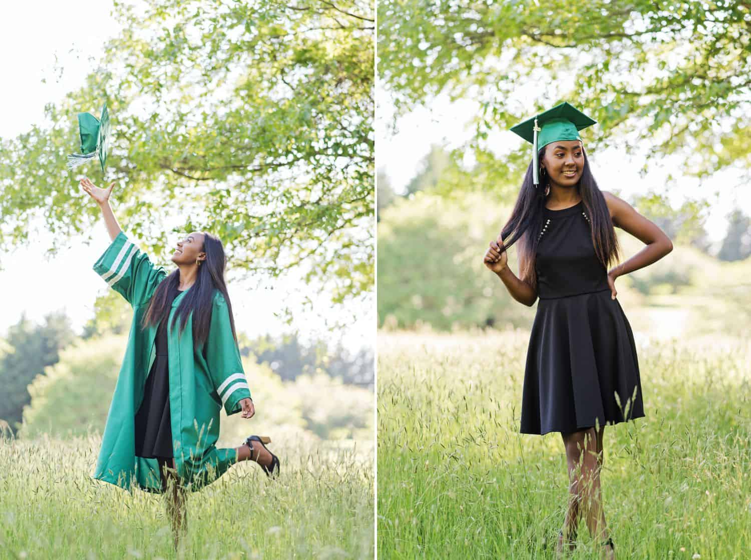 A high school senior girl poses wearing a black dress under her green graduation gown. She stands in a field and throws her cap into the air.