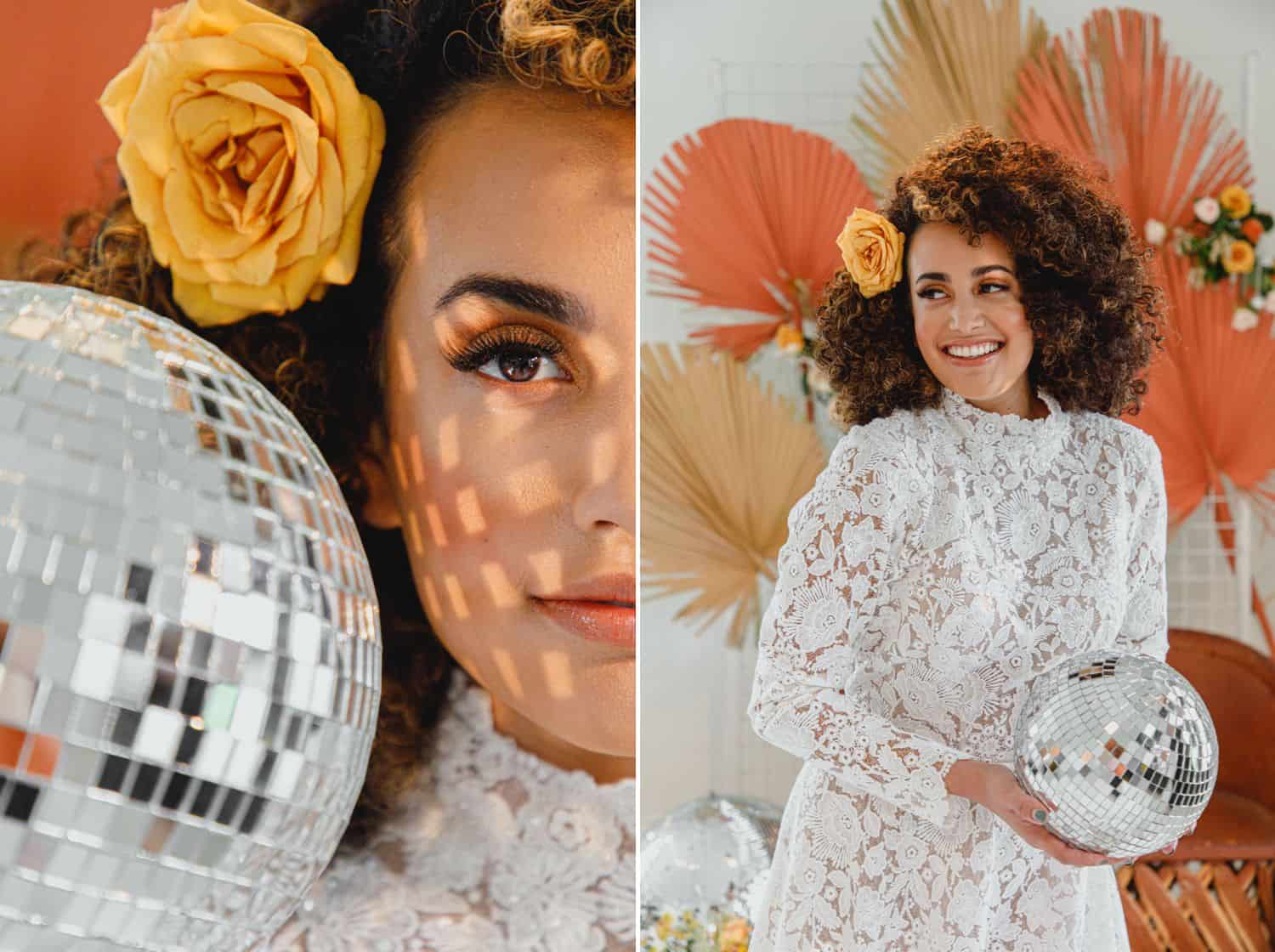 A bride poses with a disco ball while surrounded by orange and yellow flowers