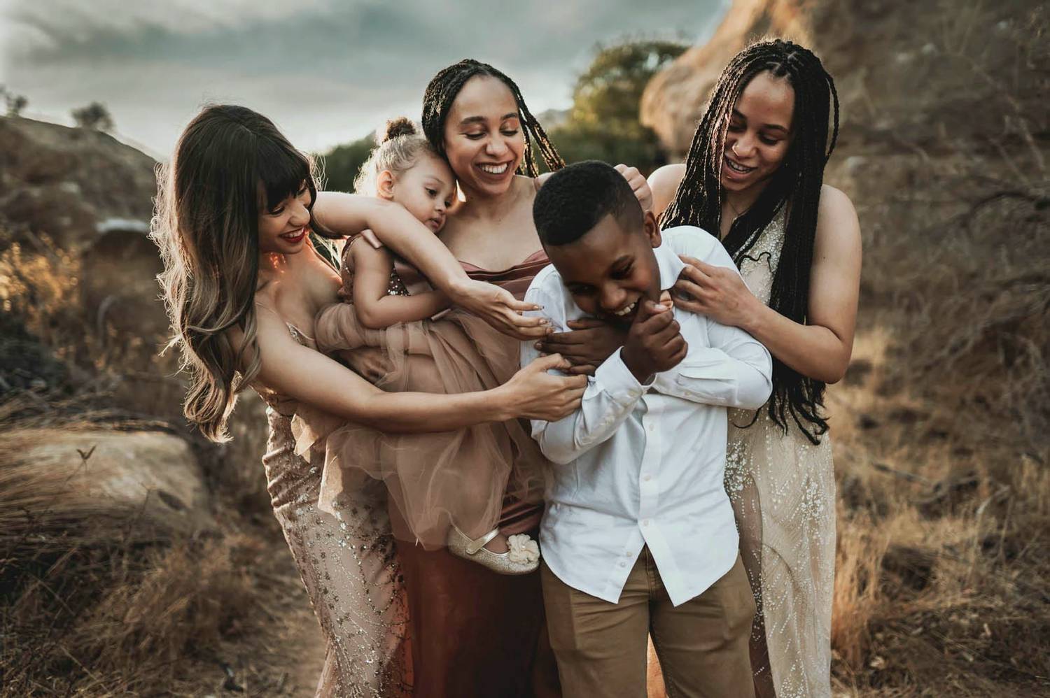 Photo: Jessie Lane's portrait depicts a multi-racial family hugging and playing outside together.