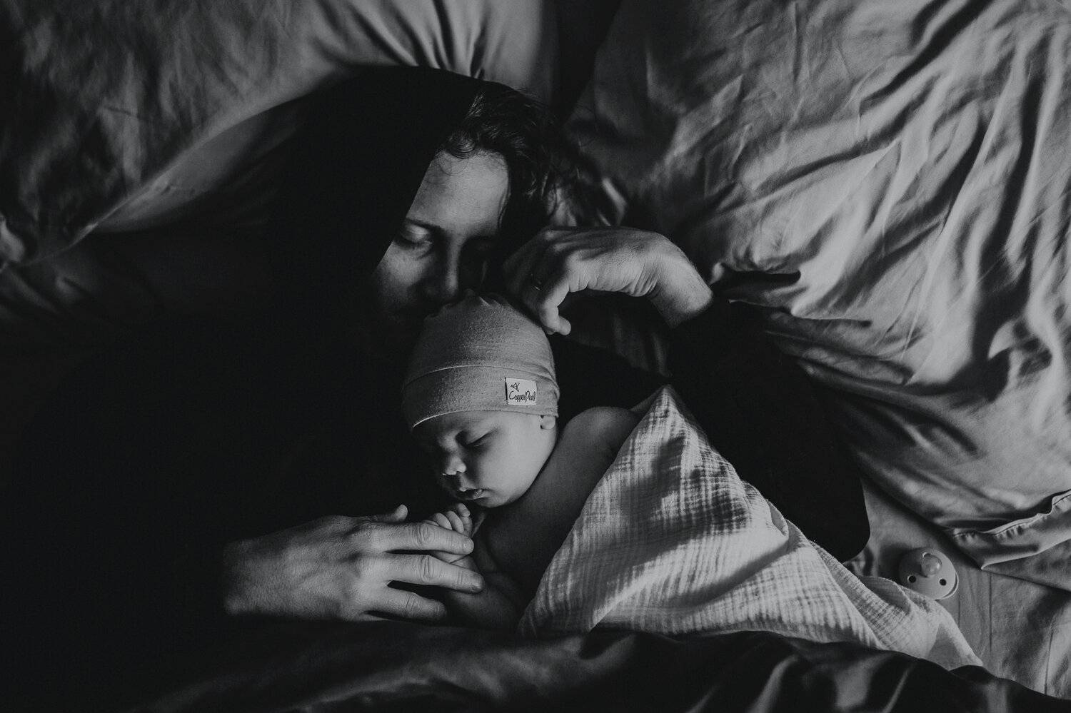Photo: Kailey Jane's in-home portrait of a mom napping with her newborn baby.