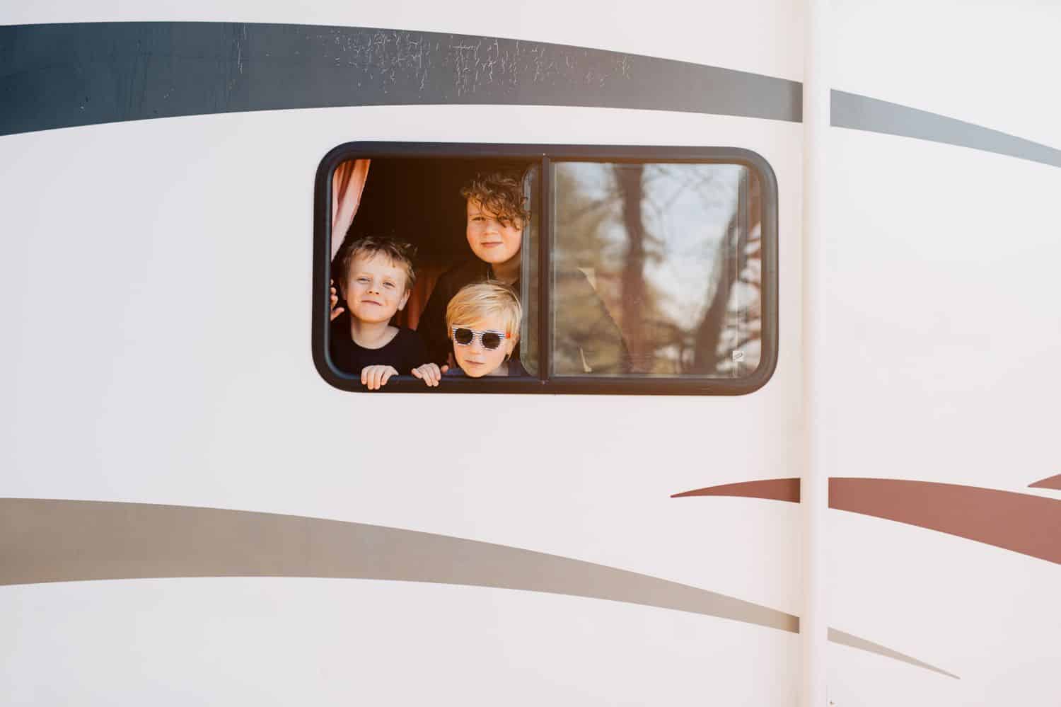 Three brothers look out the window of their RV. By Kate T. Parker for The Heart of a Boy