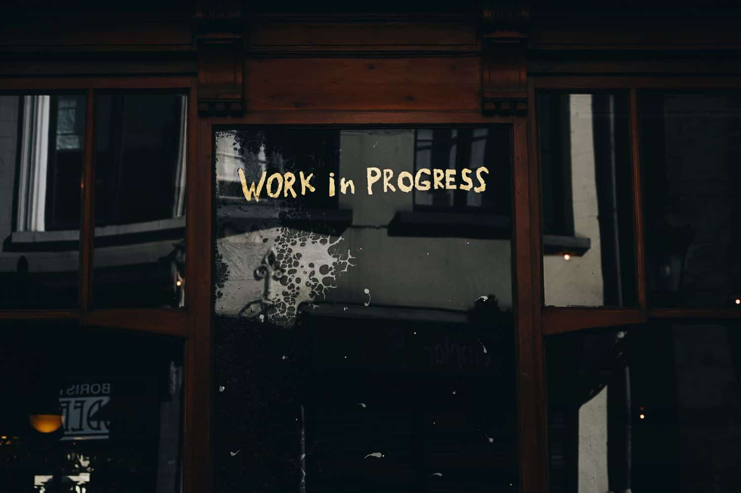 A hand-painted gold-leaf sign on a shop window reads