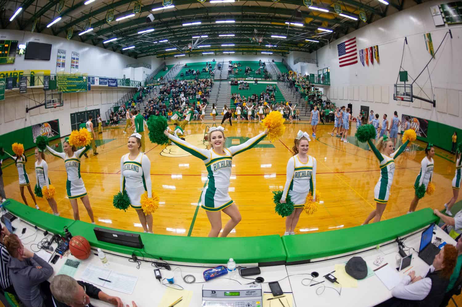 A wide angle lens helps photographer Kim Fetrow capture this image of cheerleaders at a high school basketball game