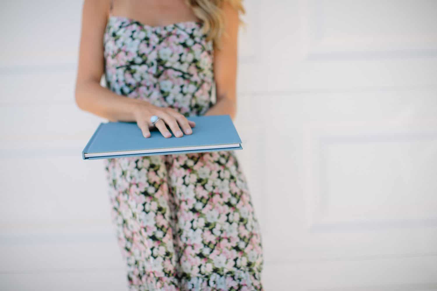 You Think You Want A Logo. What You Need Is A Legacy. Holding A Blue Linen Kiss Book