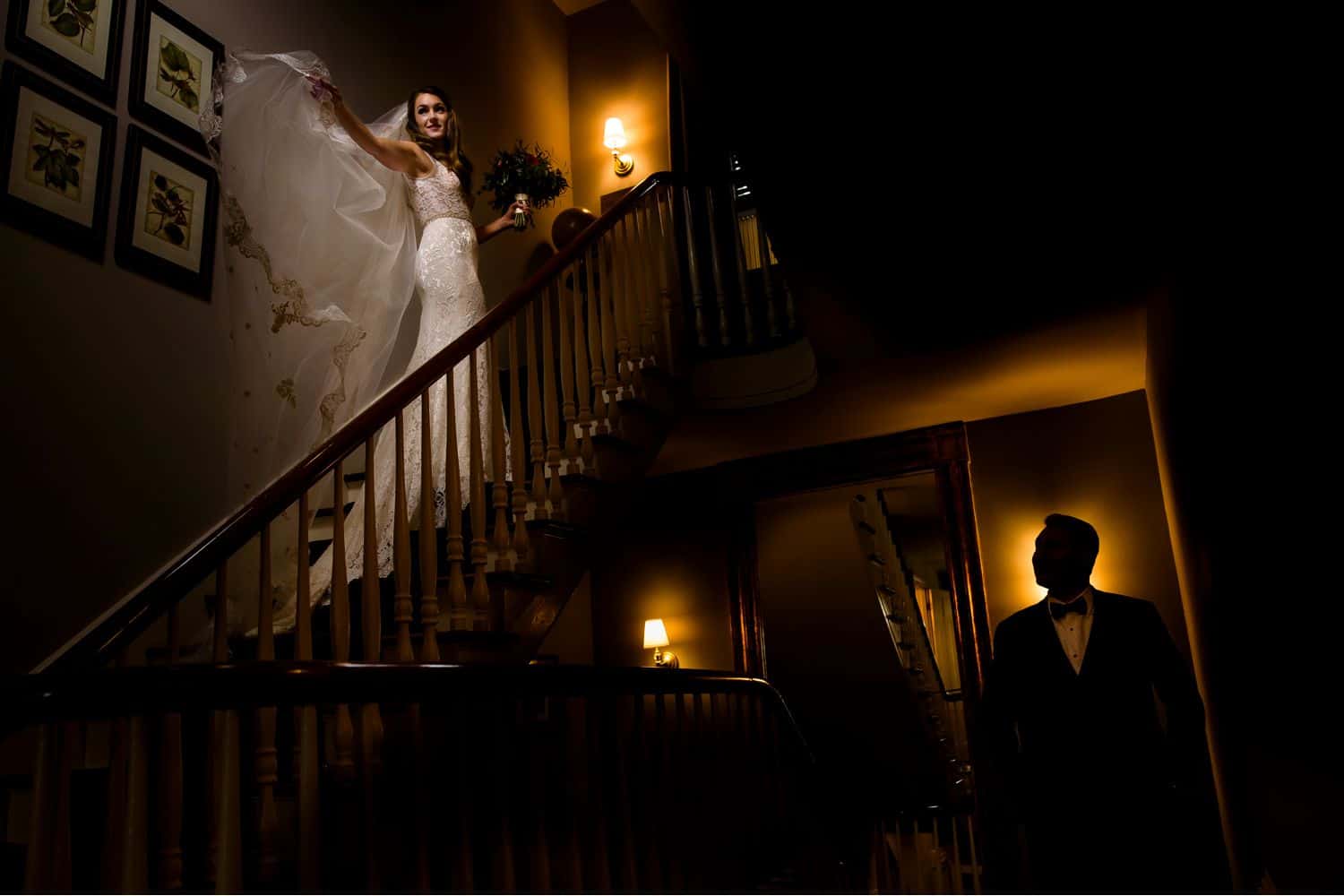 Make Money with Photography: bride stands on stairs with veil flowing while groom stands below illuminated from behind