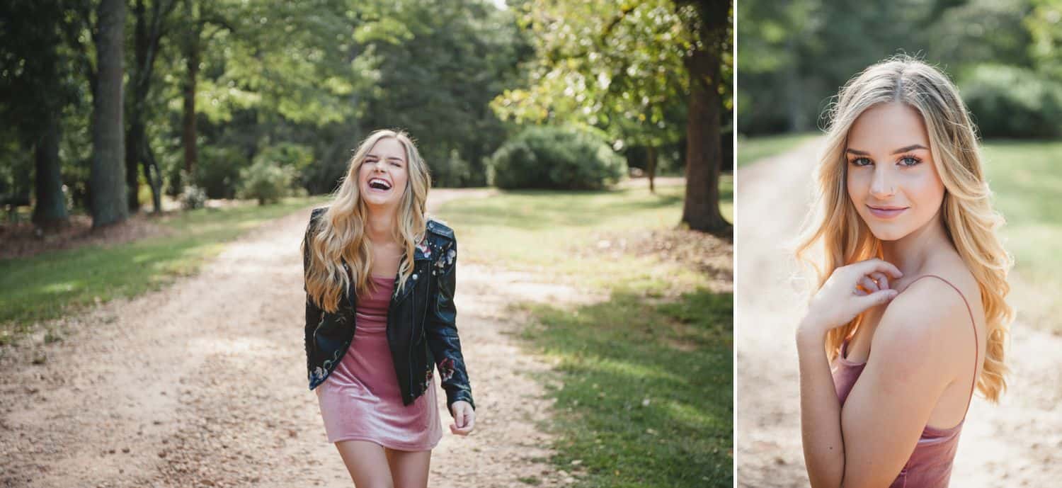 A young woman poses in a park with a leather jacket and a short pink dress.