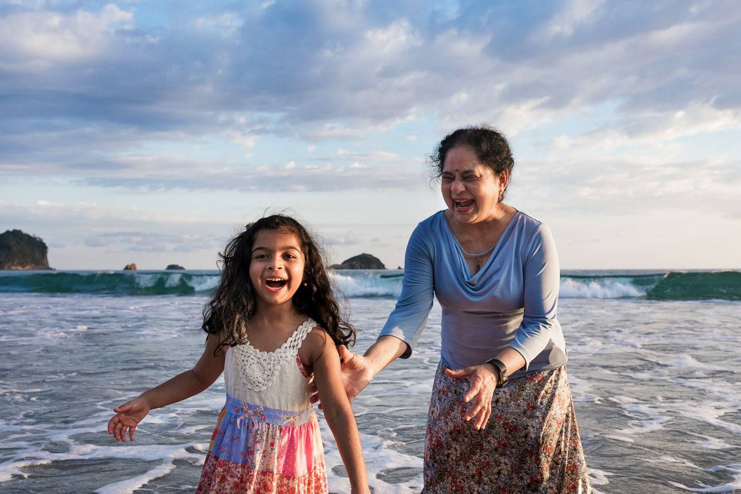 Client Experience: Kevin Heslin's photograph of an Indian woman and her granddaughter playing on a beach at sunset.