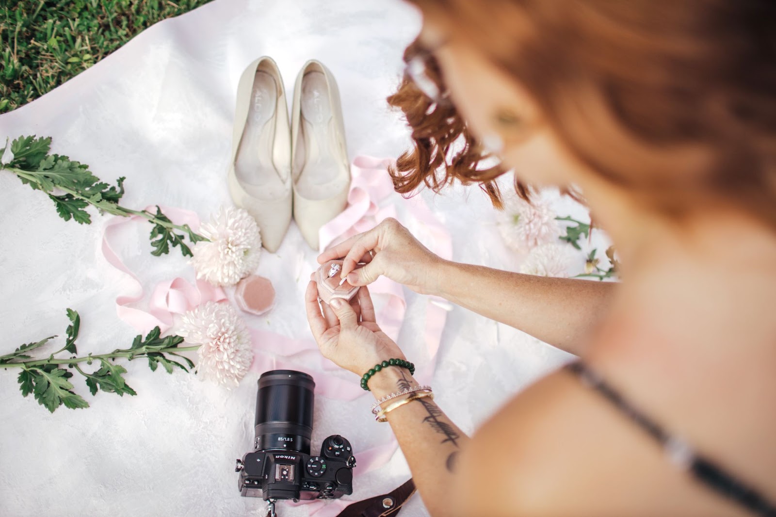 Photography setting up scene of wedding accessories