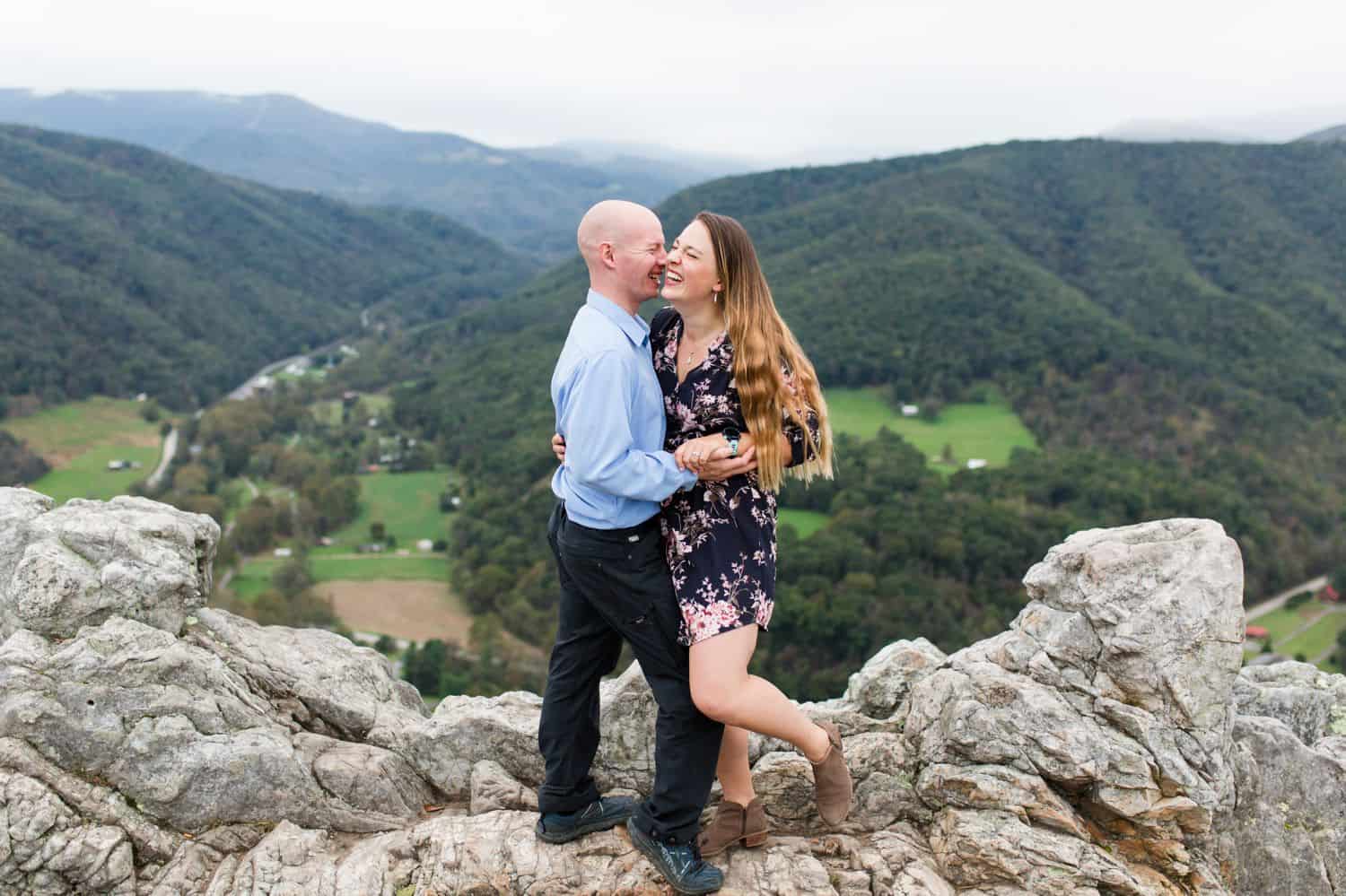 A couple hugging each other after reaching the mountain top