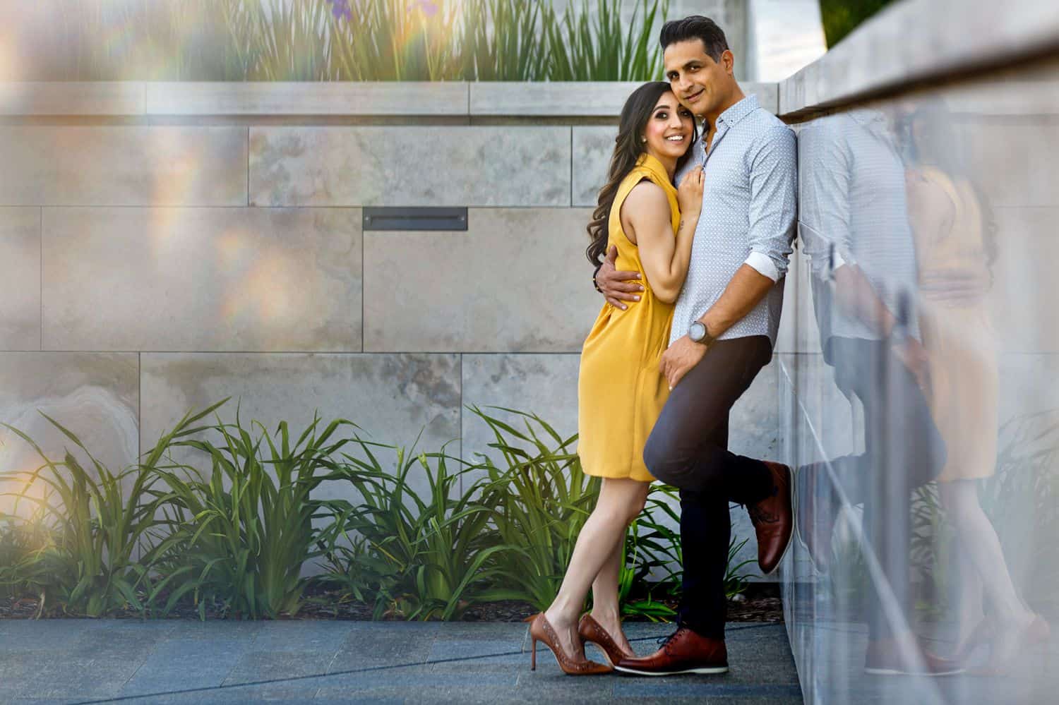 A couple posing against a wall
