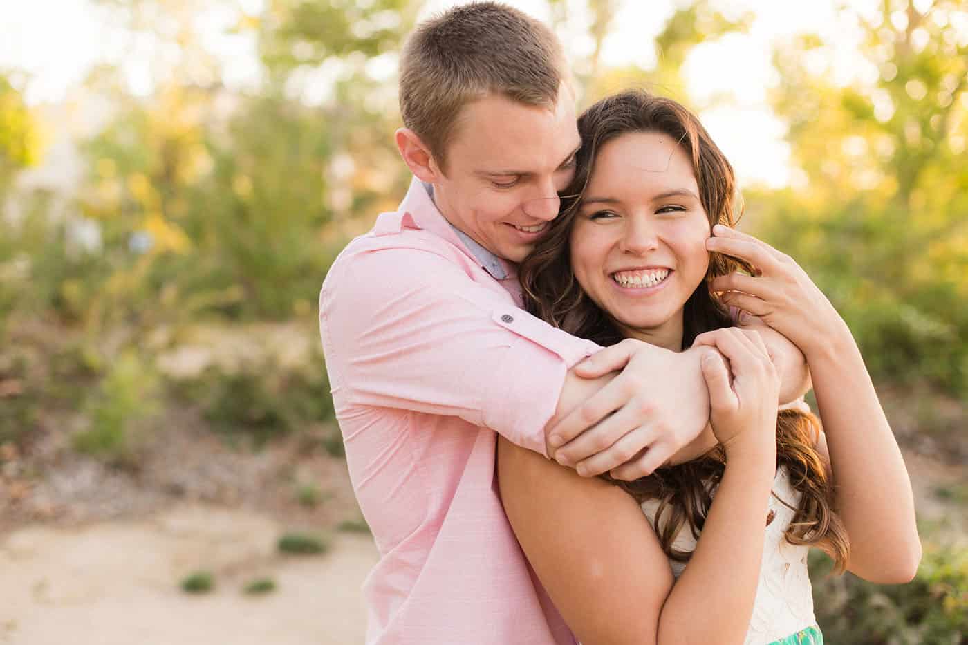 engaged couple standing in sunshine smiling by customer service whiz cinnamon wolfe