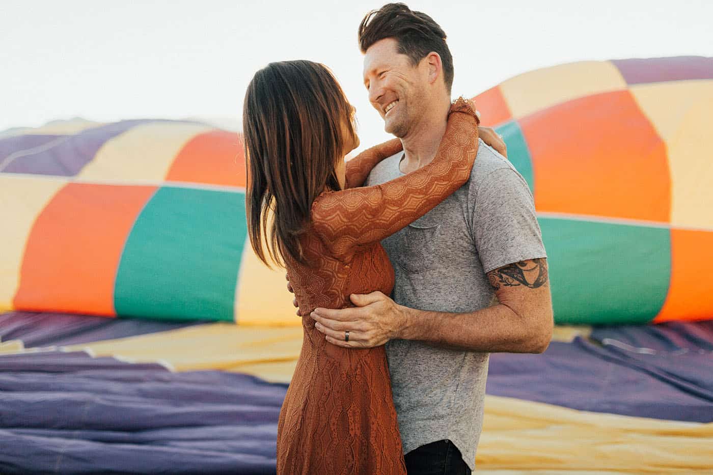 Memorable Photo Locations - tattooed couple hugging at a hot air balloon festival