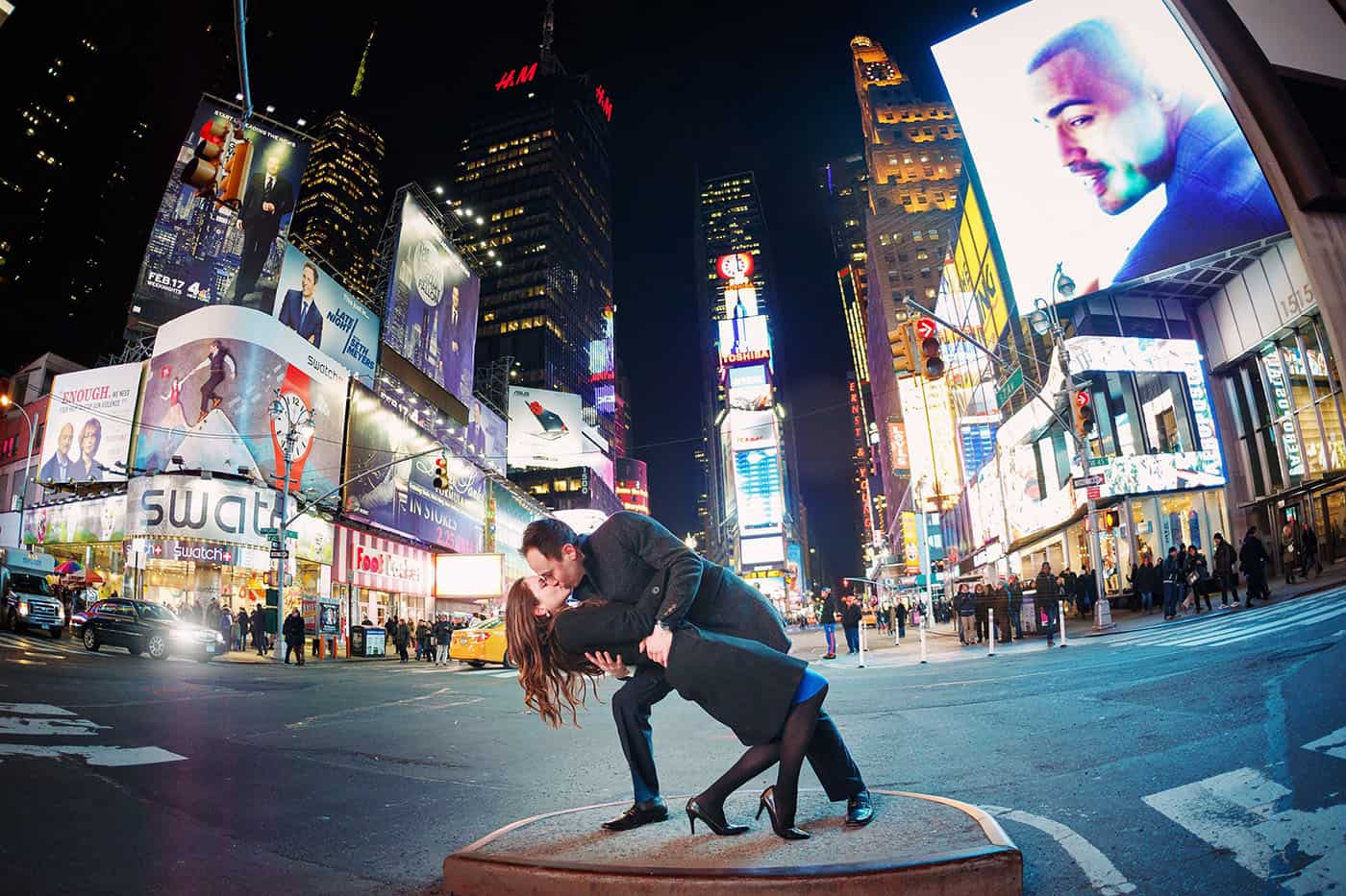 This is the Key to Amazing Client Relationships | A man dips and kisses his partner in a major Times Square intersection at nighttime.
