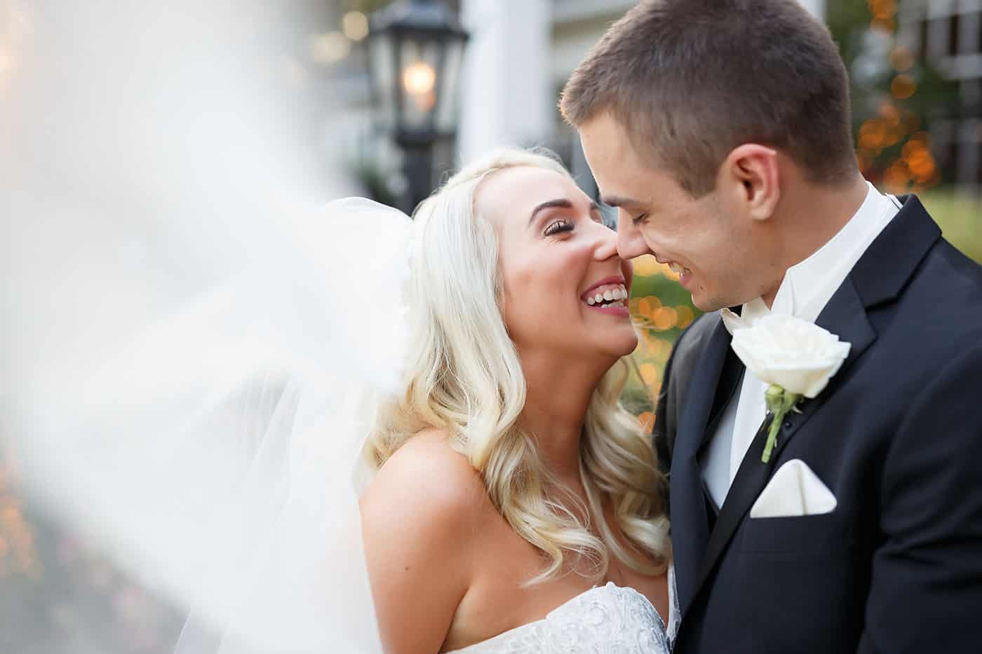 This is the Key to Amazing Client Relationships | A bride and groom move in to kiss as the bride's veil flies toward the camera lens.