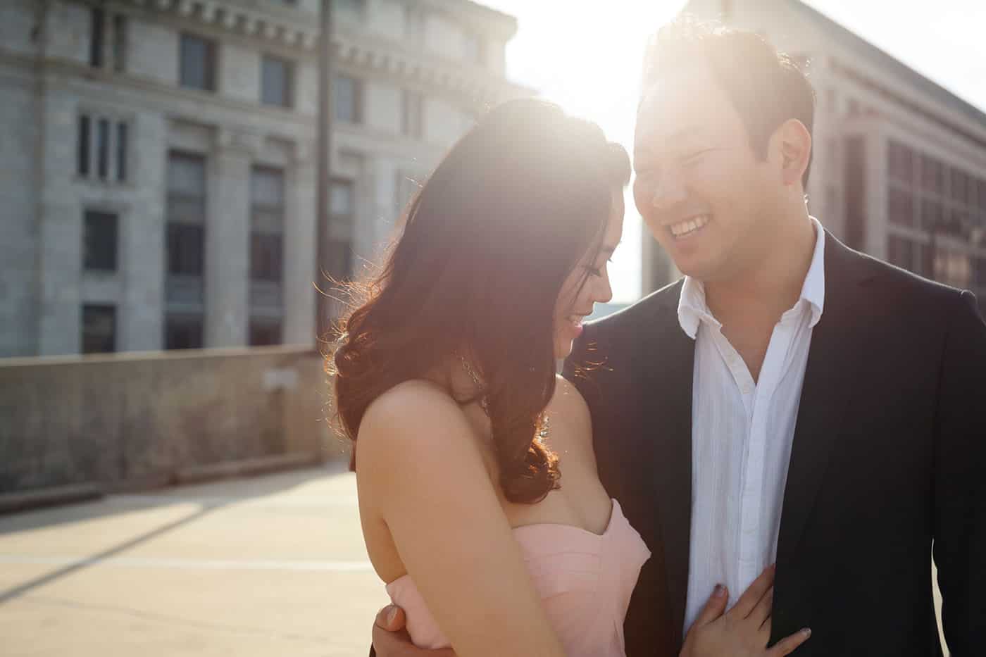 This is the Key to Amazing Client Relationships | An engaged couple leans in toward one another as a flare of sun glows behind them.