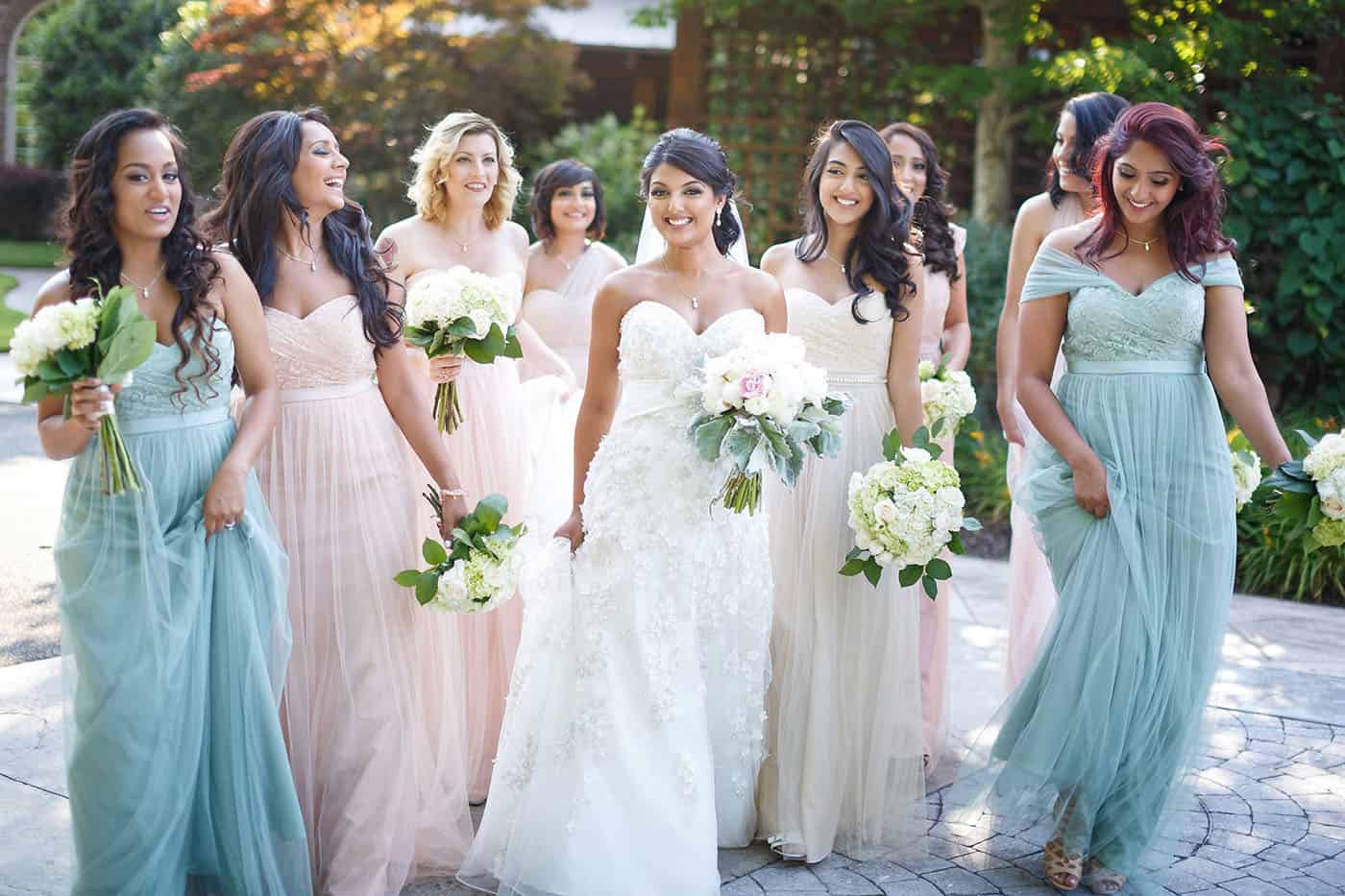 This is the Key to Amazing Client Relationships | A group of pastel-gowned bridesmaids stroll outside alongside the bride.