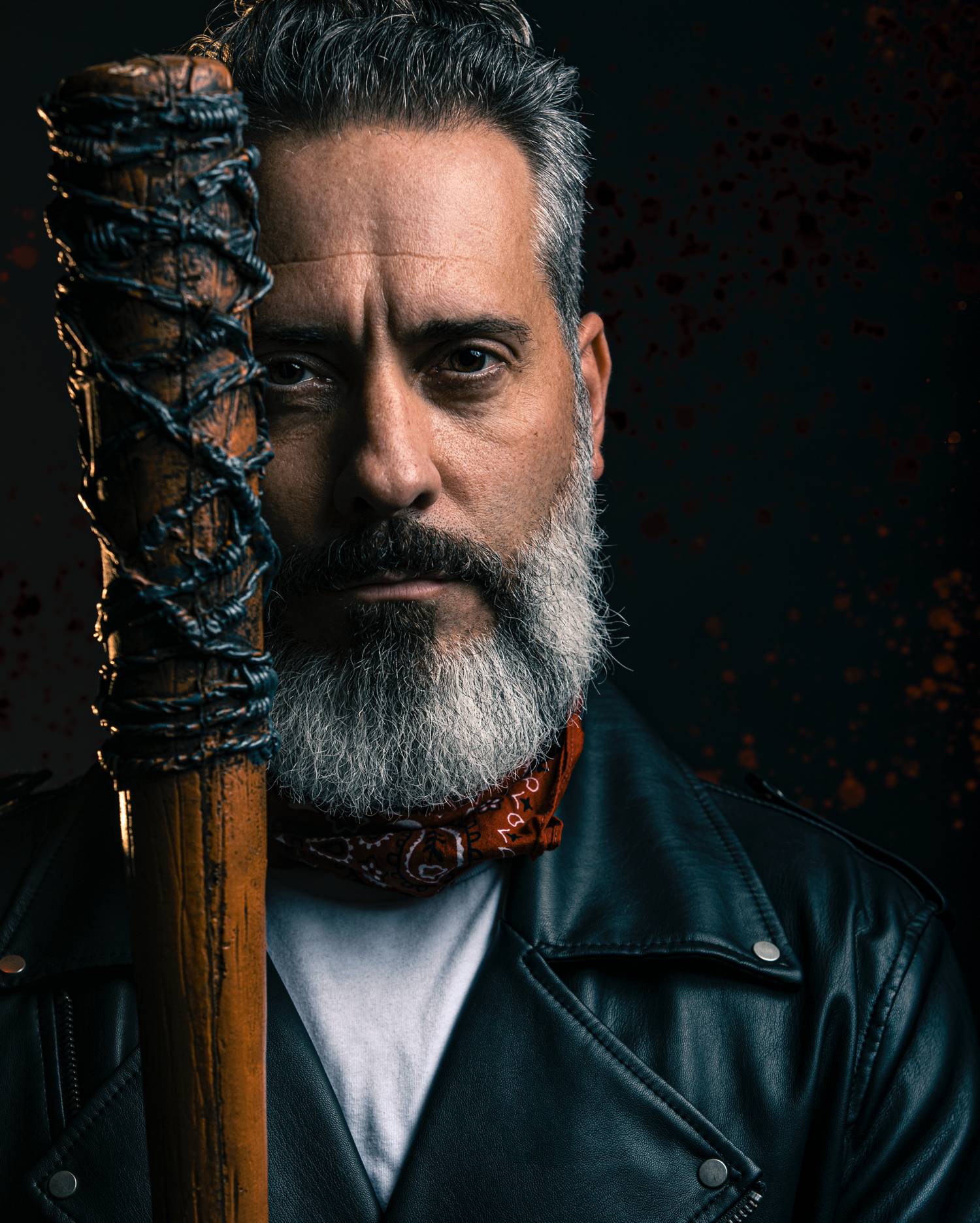 In this styled tribute photograph by Alexander Worth of Jawfox Photography, a man cosplays Negan from The Walking Dead, wearing a leather jacket and carrying the villain's barbed wire-wrapped bat, Lucille.