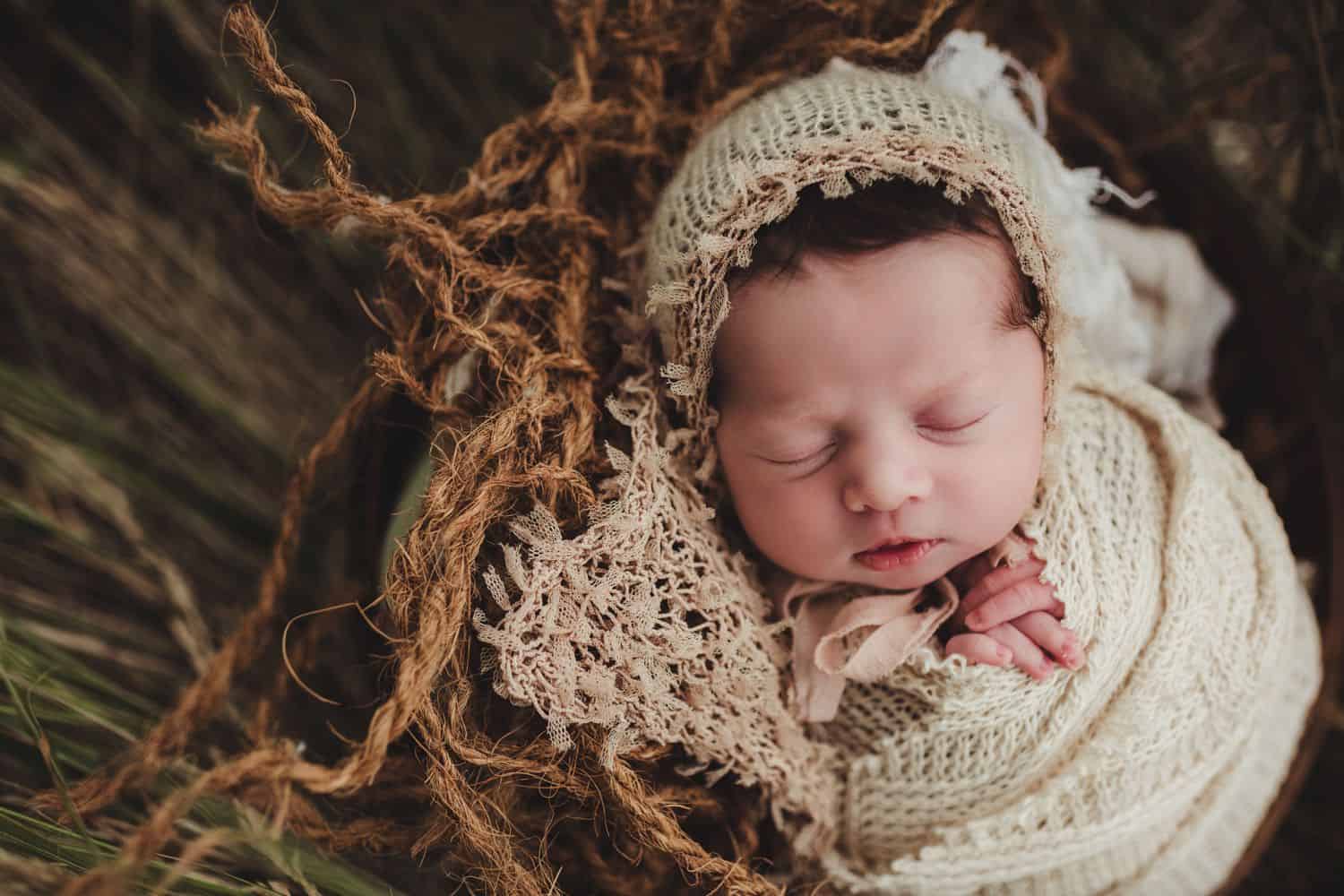 newborn wrapped in burlap and lying in a bed of reeds