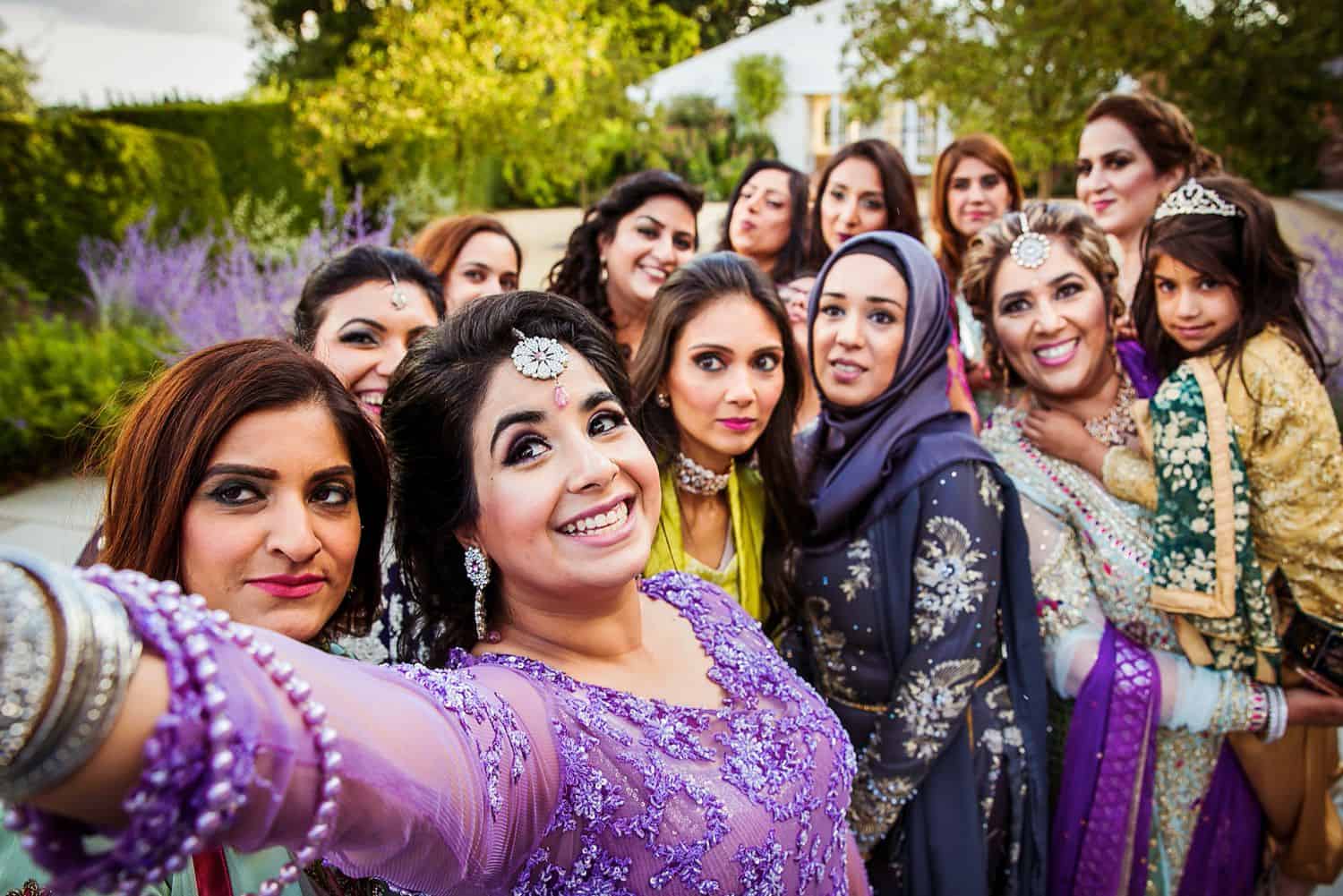 An Indian bride takes a selfie with her bridesmaids