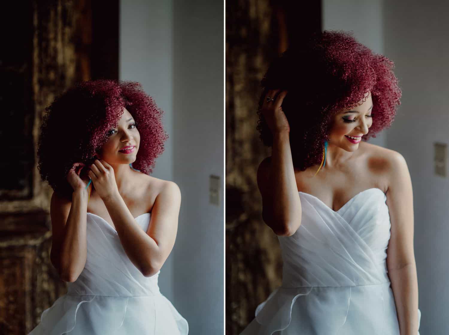 A Black bride with hot pink hair poses for a portrait while getting ready for her wedding